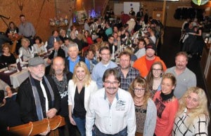 Über die Köpfe von Cheforganisator Uwe Schneider, den Pferdefreunden aus Weitefeld und den Musikern ist hier die festlich geschmückte Tafel bei der Weihnachtsparty in der Tenne in Elkenroth zu sehen. Foto: rai